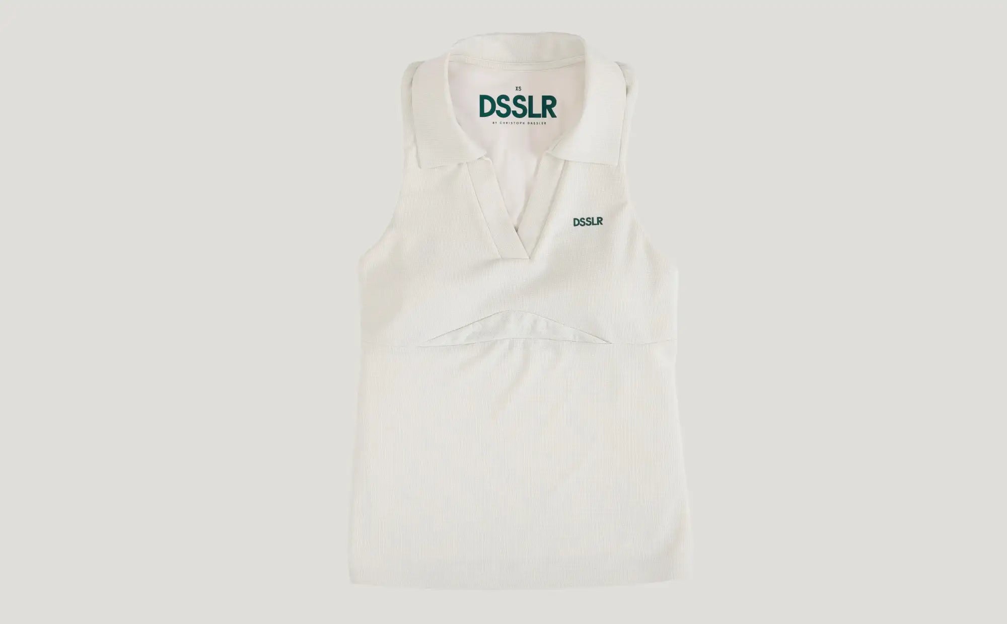 Ein knackiges weißes ärmelloses Poloshirt mit klassischem Kragen und dezentem grünem ’dsslr’-Branding auf der Brust und dem Innenetikett.