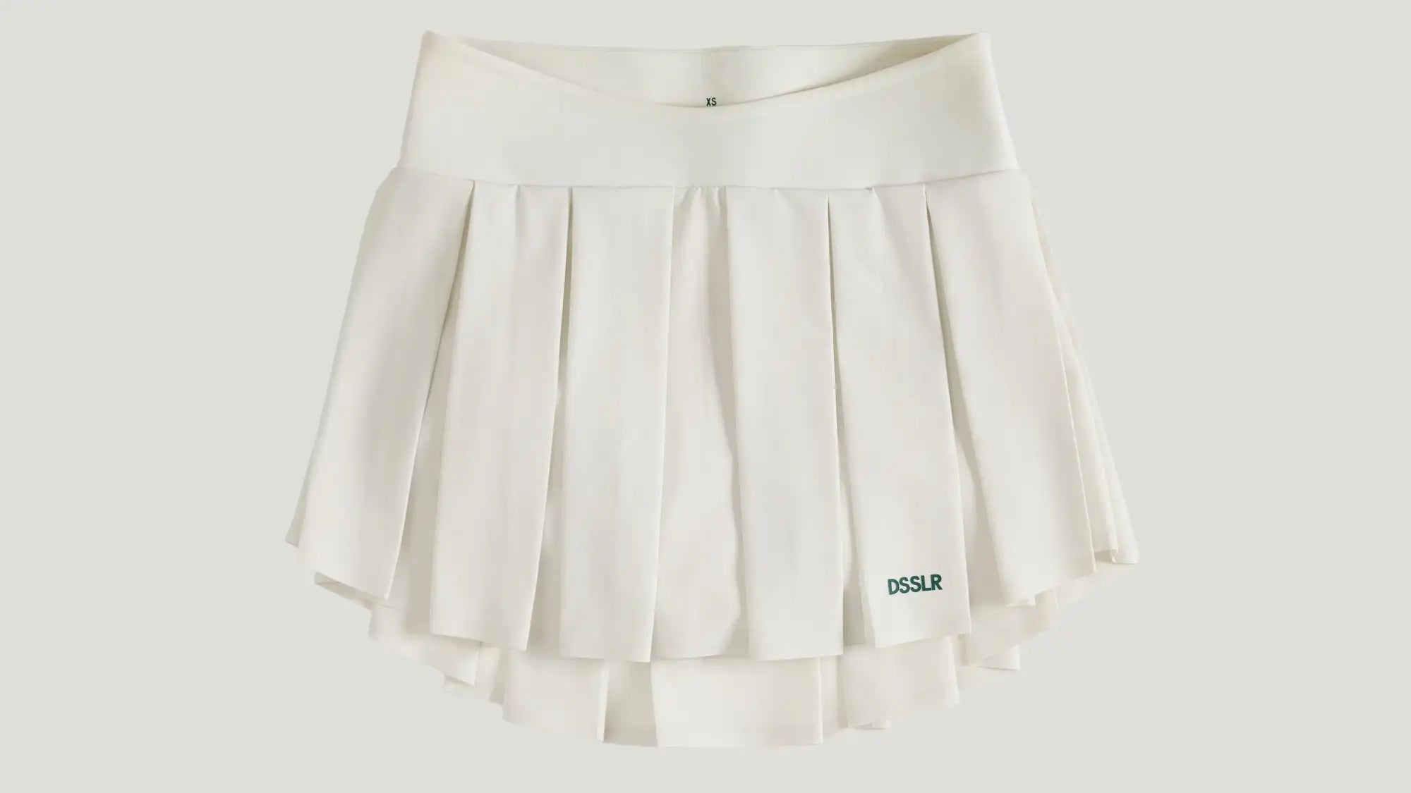 Ein knitterfreier weißer Falten-Tenniskilt mit passendem elastischem Bund und dezentem ’dsslr’-Branding auf der unteren rechten Seite.