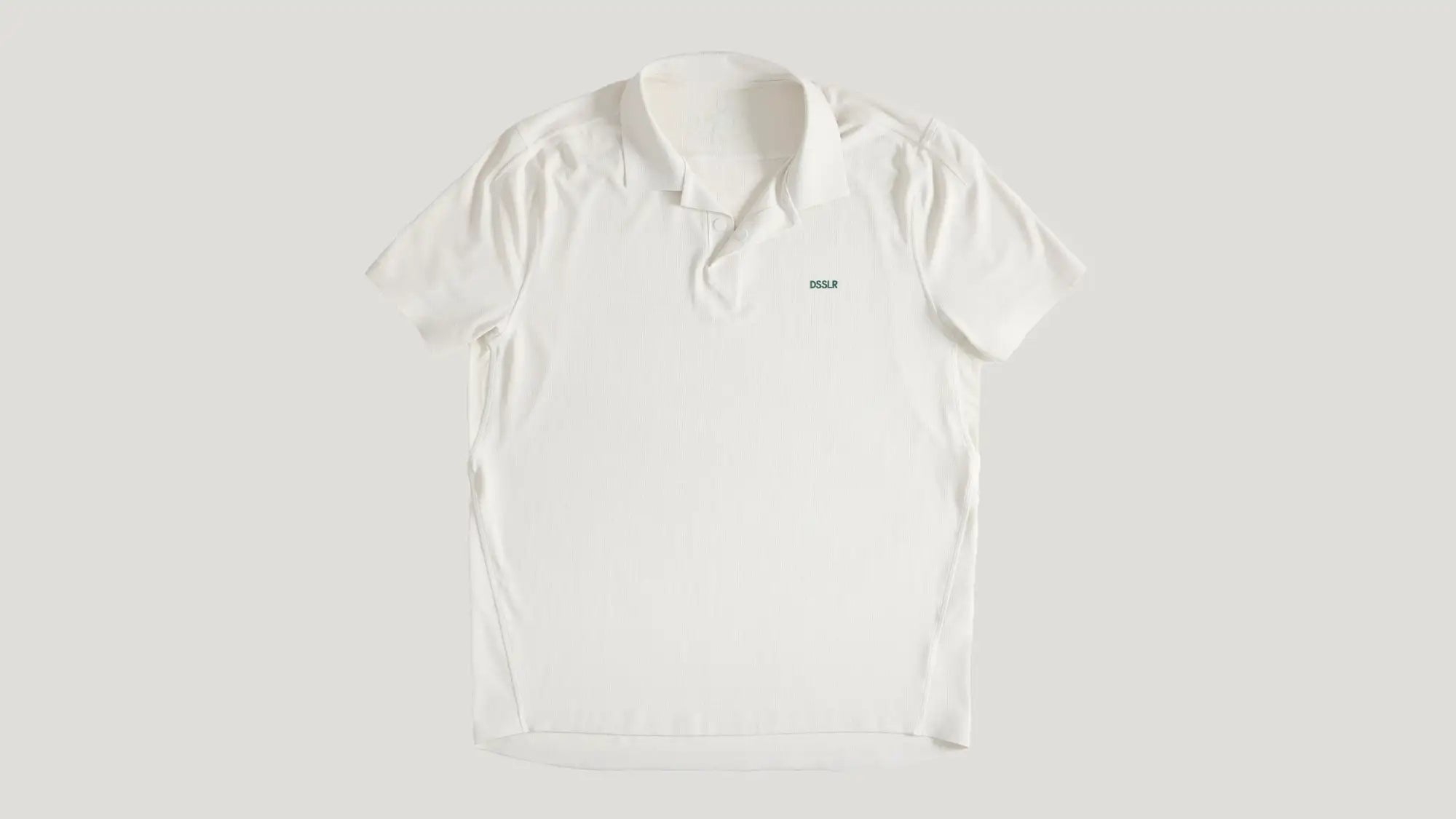 Weißes kurzärmeliges Poloshirt mit einem dezenten grünen Logo auf der linken Brust.